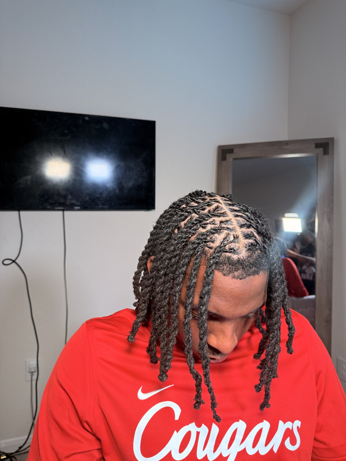 Close-up from above of a tightly braided hairline on a male client