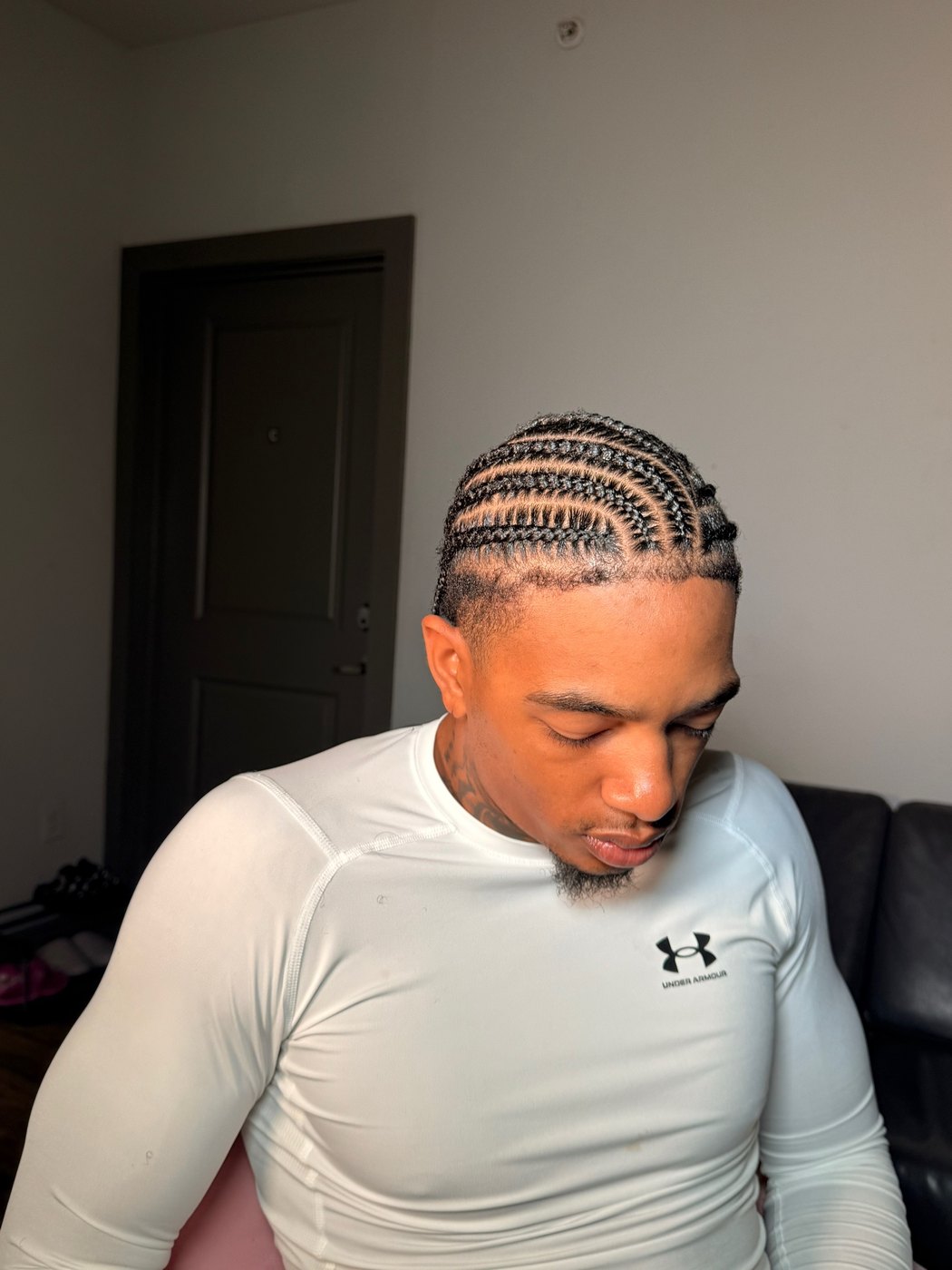 Men's cornrows with a sharp lineup, head bowed to show the pattern