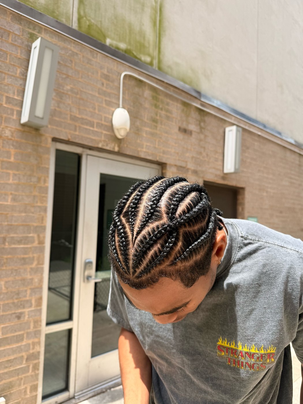 Men's stitch braids curving back from the hairline in even rows