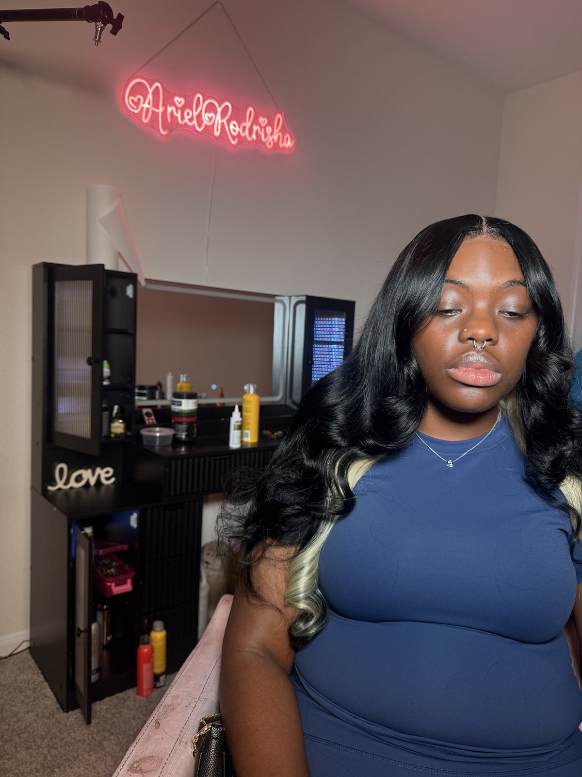 A sleek wavy lace-front install, the client in a blue top in the home studio